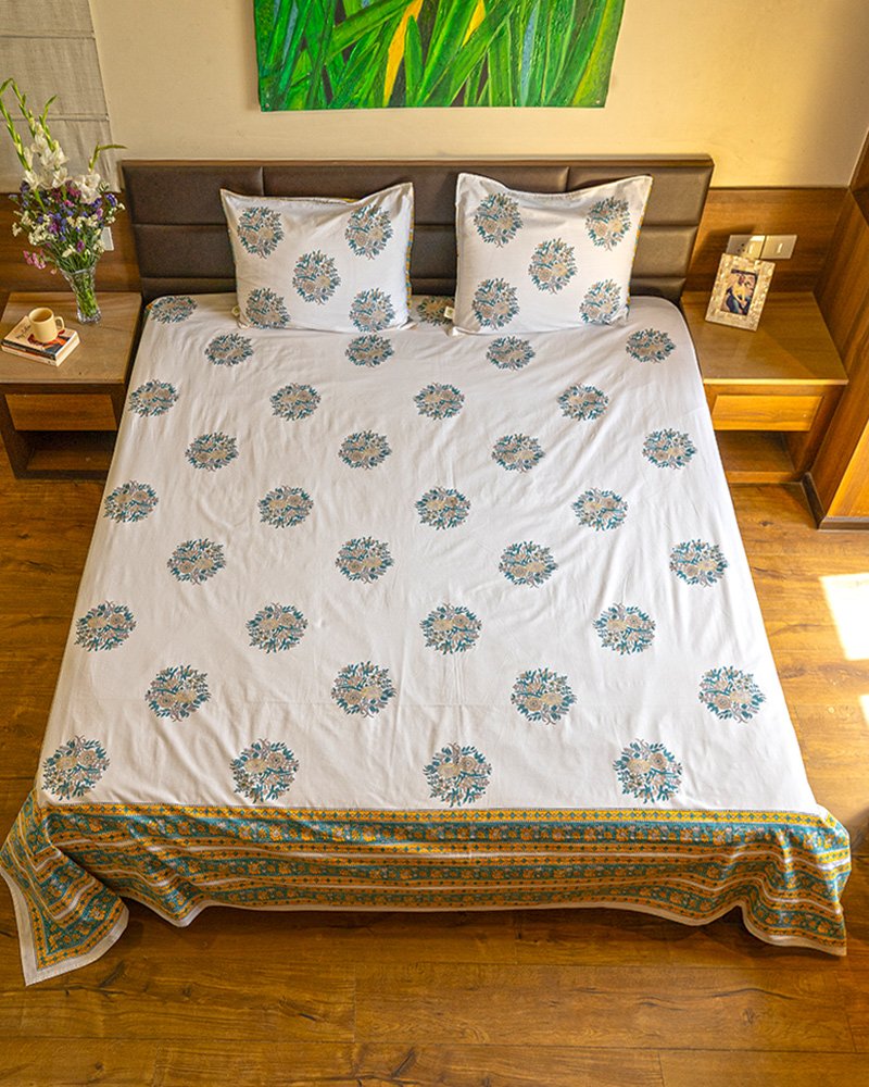 Blissful sun-kissed bed with king size organic cotton bedsheet draped in turquoise, white and peach colors