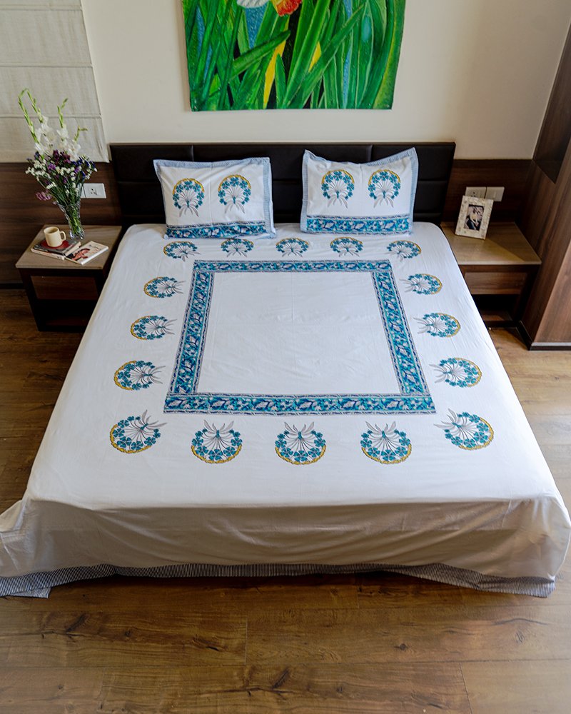 A cozy bedroom with kalaaais organic cotton king size bed sheet draped on its double bed in minimalistic block print design in blue and white color