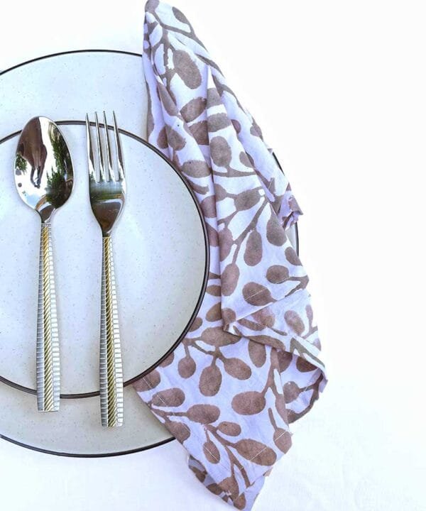 Table layed with dinner plate, quarter plate, cutlery and organic cotton hand block print dinner napkins for elite dining experience.