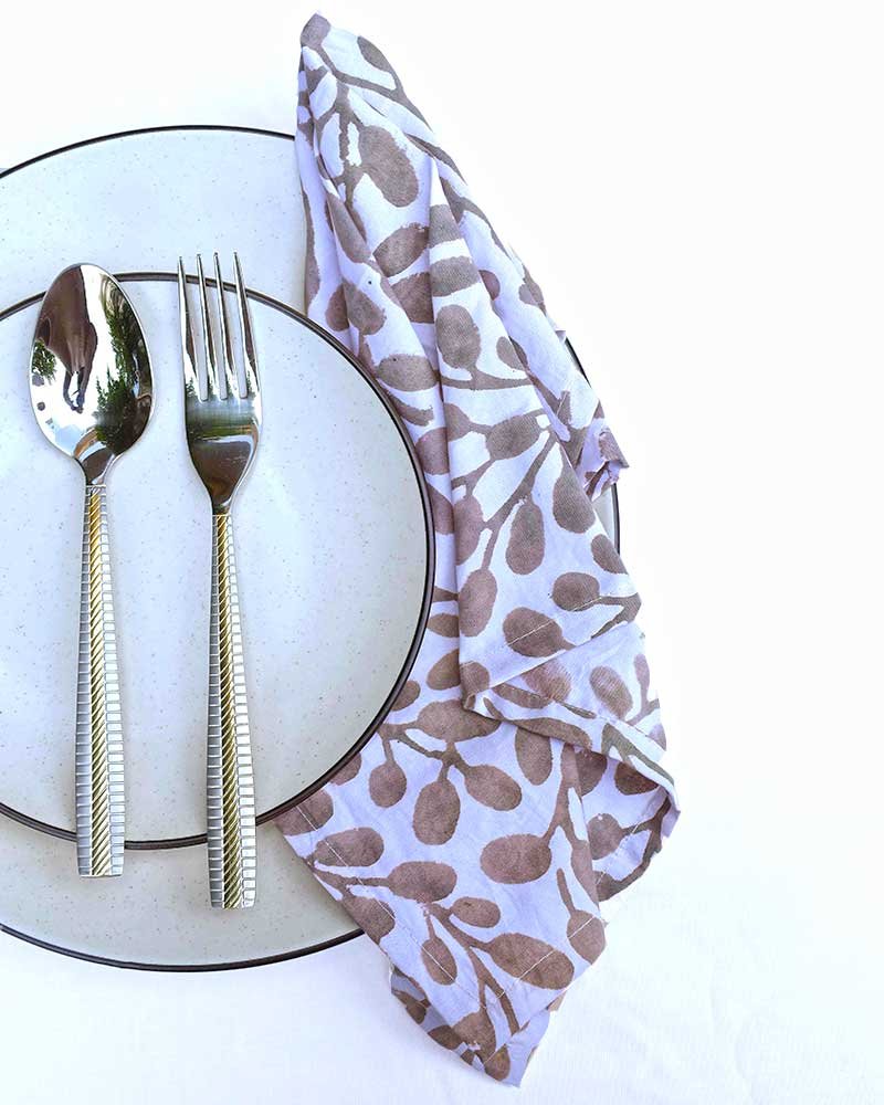 Table layed with dinner plate, quarter plate, cutlery and organic cotton hand block print dinner napkins for elite dining experience.