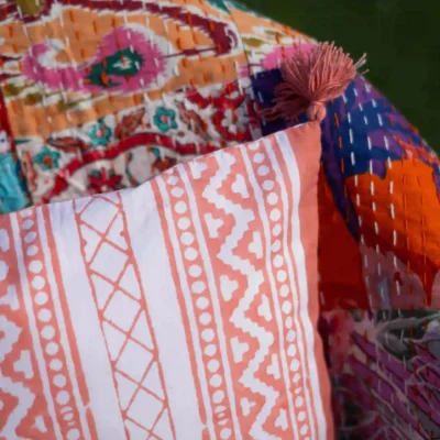 Victory Stripes organic cotton block print cushion cover with pom poms in peach colored striped design. Retirement gift.