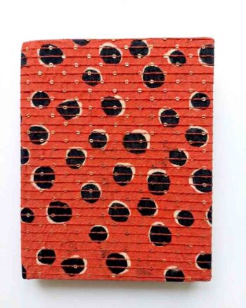 Handcrafted sequin notebook with red and black dot print fabric cover placed on a white background, featuring artisanal detailing and elegant handmade design.