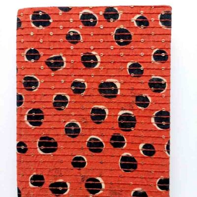 Handcrafted sequin notebook with red and black dot print fabric cover placed on a white background, featuring artisanal detailing and elegant handmade design.
