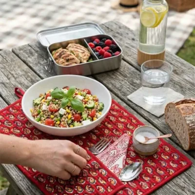 Hand block printed Paisley Roll-Up Travel Mat set by Kalaaai featuring a deep red quilted cotton mat with yellow paisley motifs, integrated cutlery pocket, reusable spoon, fork, and napkin. A heritage-inspired, eco-friendly lifestyle accessory designed for sustainable dining on the go.