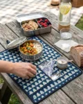 Indigo Mosaic Roll-Up Travel Dining Mat by Kalaaai Jaipur featuring heritage-inspired geometric tile patterns in indigo and white, handcrafted quilted cotton construction, integrated cutlery pocket, spoon, fork, and reusable napkin for sustainable dining and travel.