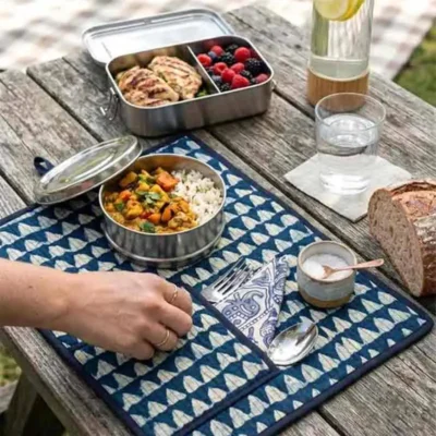 Indigo Mosaic Roll-Up Travel Dining Mat by Kalaaai Jaipur featuring heritage-inspired geometric tile patterns in indigo and white, handcrafted quilted cotton construction, integrated cutlery pocket, spoon, fork, and reusable napkin for sustainable dining and travel.