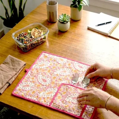 Kalaaai Paisley Roll-Up Travel Mat in pink hand block print, handcrafted quilted cotton dining mat with cutlery pocket, inspired by Indian heritage textiles and sustainable living being used in office for lunch